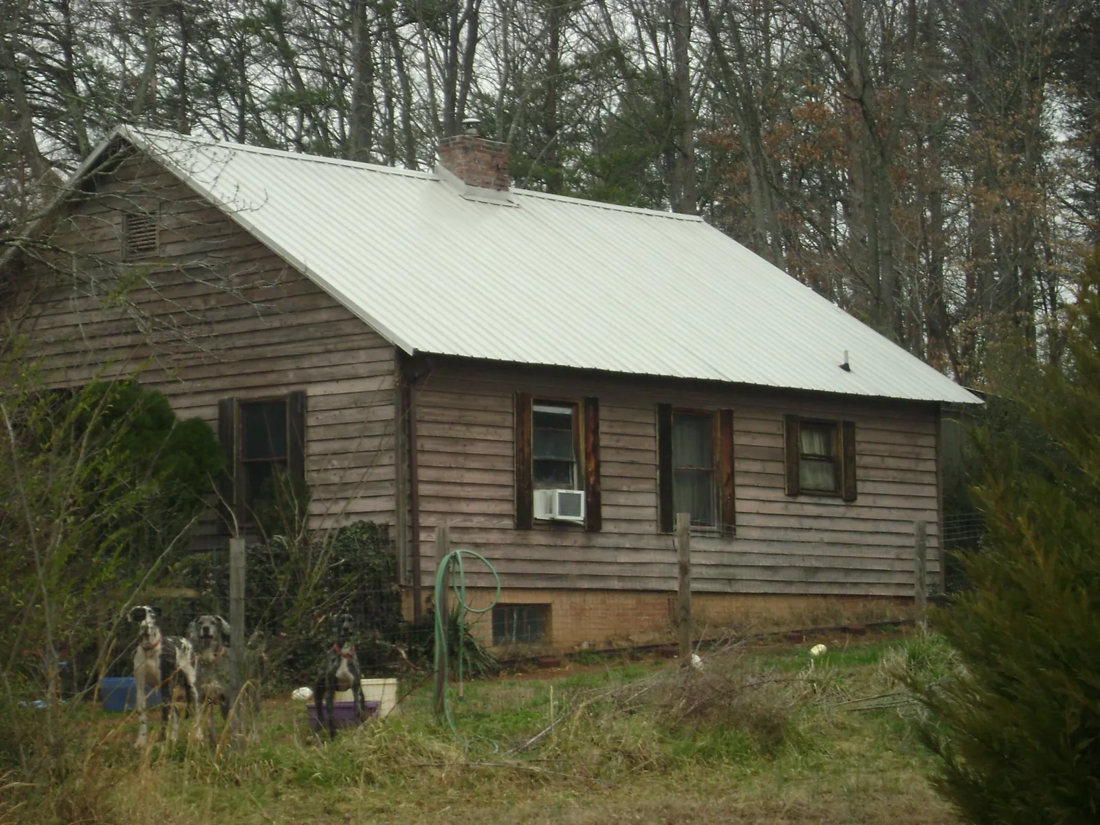 White metal roof on an old wood sided farmhouse, from a Metal Roof Installation job in Greenville
